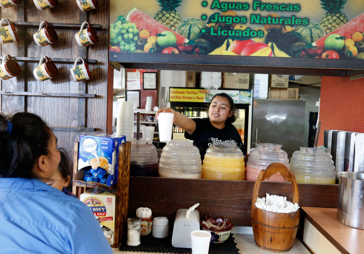Jocelyn Flores, right, hands cup of aguas frescas through a window to Betty Mondragon at Taqueria Molcajetes, in Santa Rosa, on Wednesday, April 25, 2018. (Alvin Jornada)
