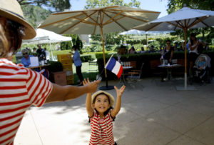 7/15/2013: B1: PC: Sofia Pomares, 4, reaches for a French flag waved by her mother, Fabiola Pomares- Sotomayor, while celebrating Bastille Day at Chateau St. Jean on Sunday, July 14, 2013 in Kenwood, California. (BETH SCHLANKER/ The Press Democrat)