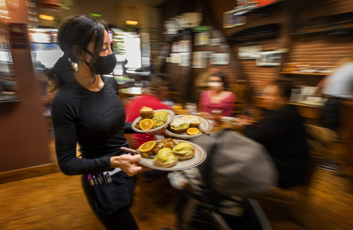 Server Katie Thornburgh balances plates of breakfast for customers at Omelette Express in Santa Rosa on Friday, May 21, 2021. Sonoma County restaurants and hotels are struggling to hire enough workers as the summer season and state's full reopening approaches. (Photo by John Burgess/The Press Democrat)