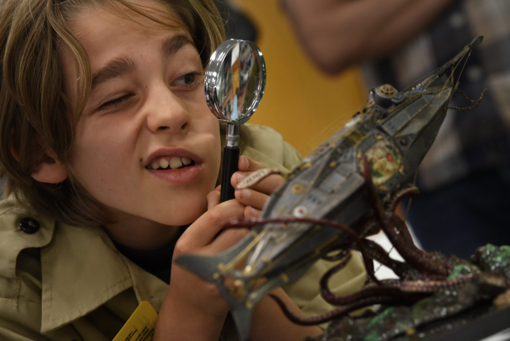 Jonas Merrill, 11, of Rhonert Park uses a magnifying glass to inspect a model titled "The Nautilus," at Fundemonium toy and hobby store in Rhonert Park, California. The model creator Micheal Coggburn was on-hand to answer any questions about his creation which was featured in an issue of FineScale Modeler Magazine. April 13, 2019. (Photo: Erik Castro/for The Press Democrat)
