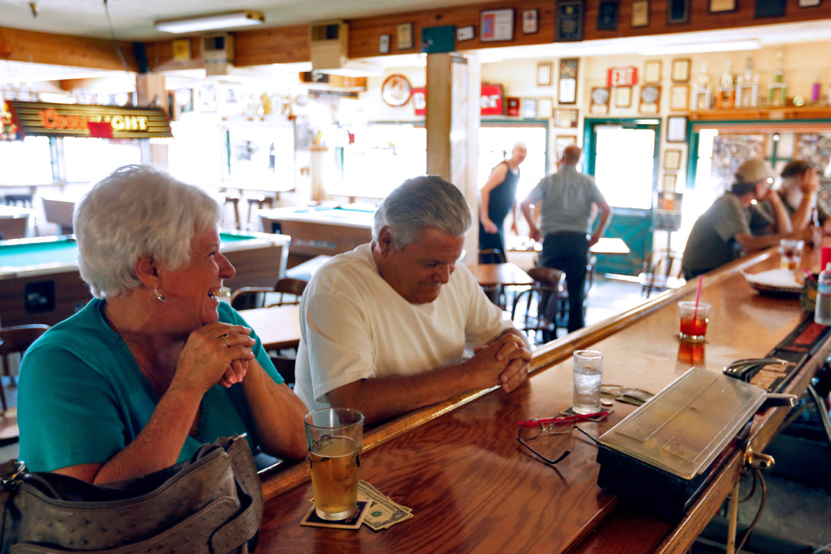 Regular patrons Carol Bishop, left, and Ernie Ruano laugh together over drinks at Willowbrook Ale House in Petaluma, California on Saturday, September 19, 2015. (Alvin Jornada / The Press Democrat)