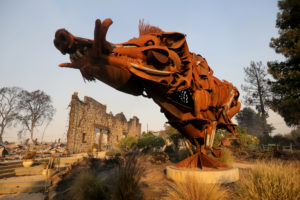 A sculpture of a wild boar called "Lord Snort" stands in front of the charred facade of Soda Rock Winery, which burned during the Kincade fire in Healdsburg on Sunday, October 27, 2019. (Beth Schlanker / The Press Democrat)
