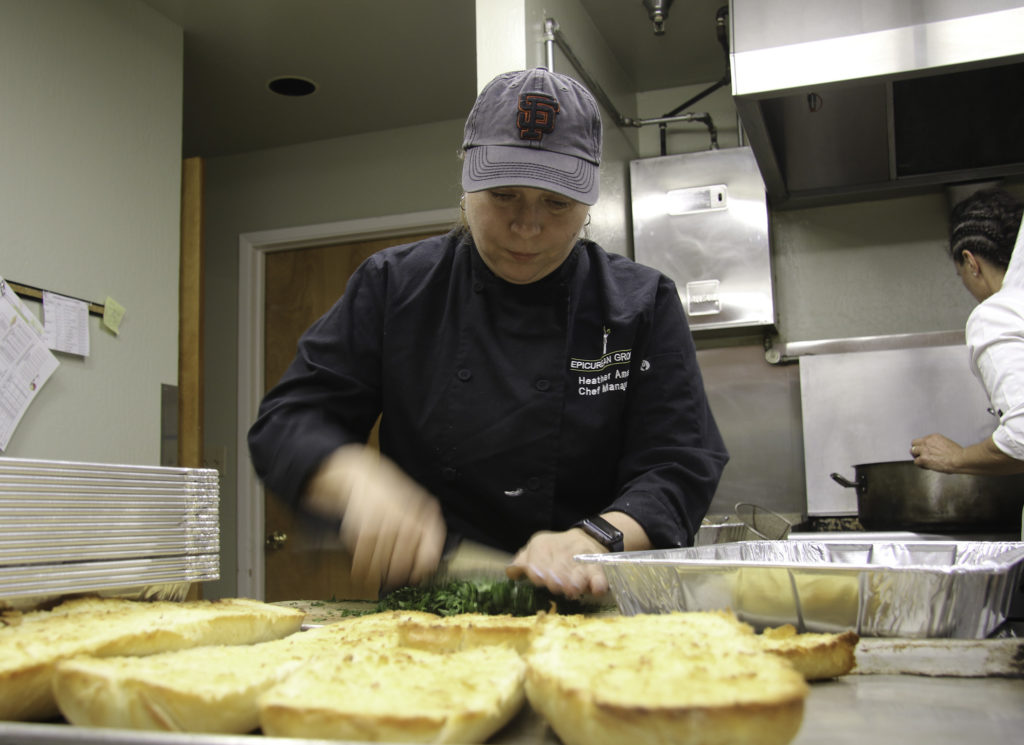Chef Heather Ames of Sonoma Family Meal prepares garlic bread at the Healdsburg Senior Center on Thursday evening. Heather Irwin/PD