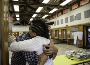 Domenica Catelli hugs Osvaldo Jimenez of Moustache Baked Goods at the Healdsburg evacuation center. Heather Irwin/PD