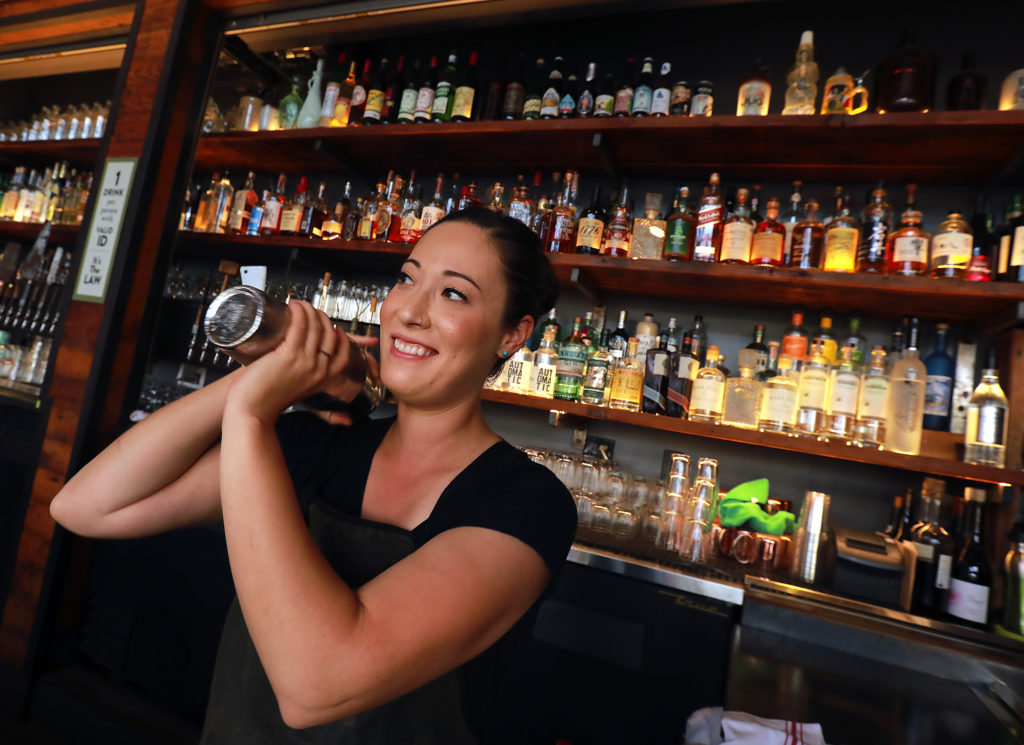Bartender Danielle Peters shakes up a cocktail at Brewster's Beer Garden in Petaluma. (John Burgess/The Press Democrat)