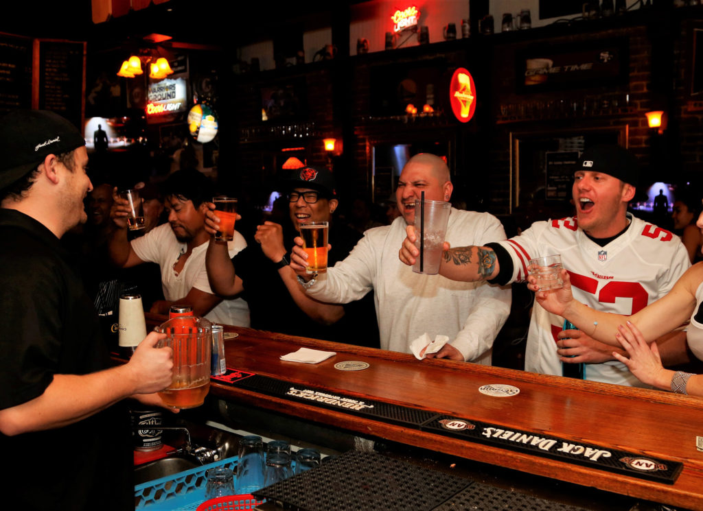 Bar Bartender, Ryan Collingwood pours beer for thirsty Superbowl partiers, from left, Dhernandez Cato, Andres Galindo, Greg Ennis and Katie Volker at Ausiello's sports bar in Santa Rosa, Sunday February 4th, 2018. (Photos Will Bucquoy/for the Press democrat)