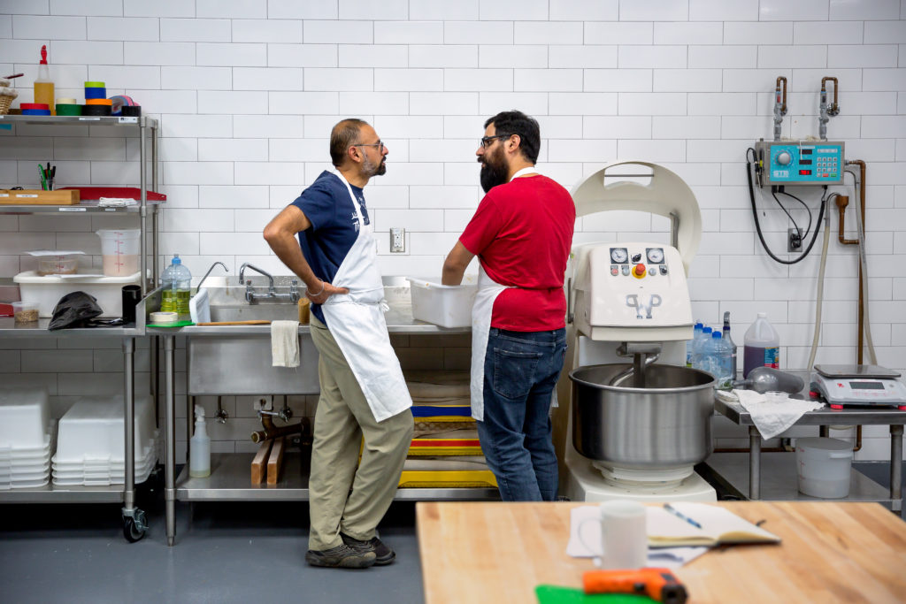 Students Nirupam Singh and Eduardo Guillen discuss dough mixing. (Chris Hardy)