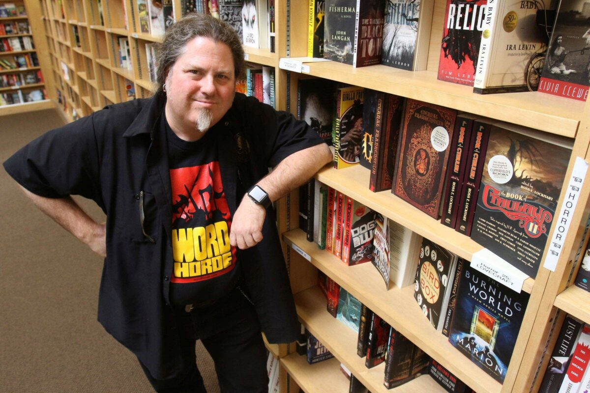 Ross Lockhart, publisher of horror books through his Petaluma based company Word Horde Books, next to shelves containing many of his books at Copperfield's Books in Petaluma on Monday afternoon July 3, 2017. (Scott Manchester/For The Argus-Courier)