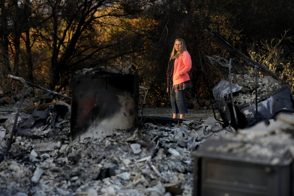 Meghan Dixon stands next to the ruins of her rental home on Hwy 128 in Healdsburg after it burned in the Kincade fire. Photo taken on Monday, November 4, 2019. (BETH SCHLANKER/ The Press Democrat)