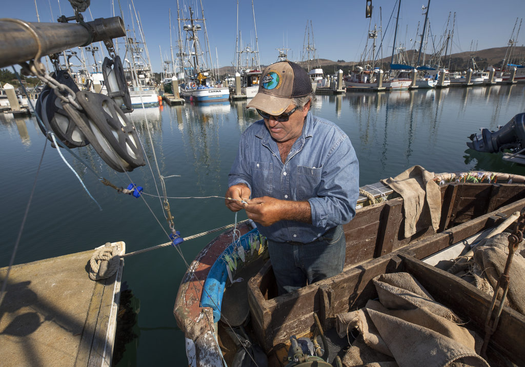 Jeff Genovese works on his salmon gear aboard the La Dolce Vita at the Spud Point Marina in Bodega Bay. (John Burgess)