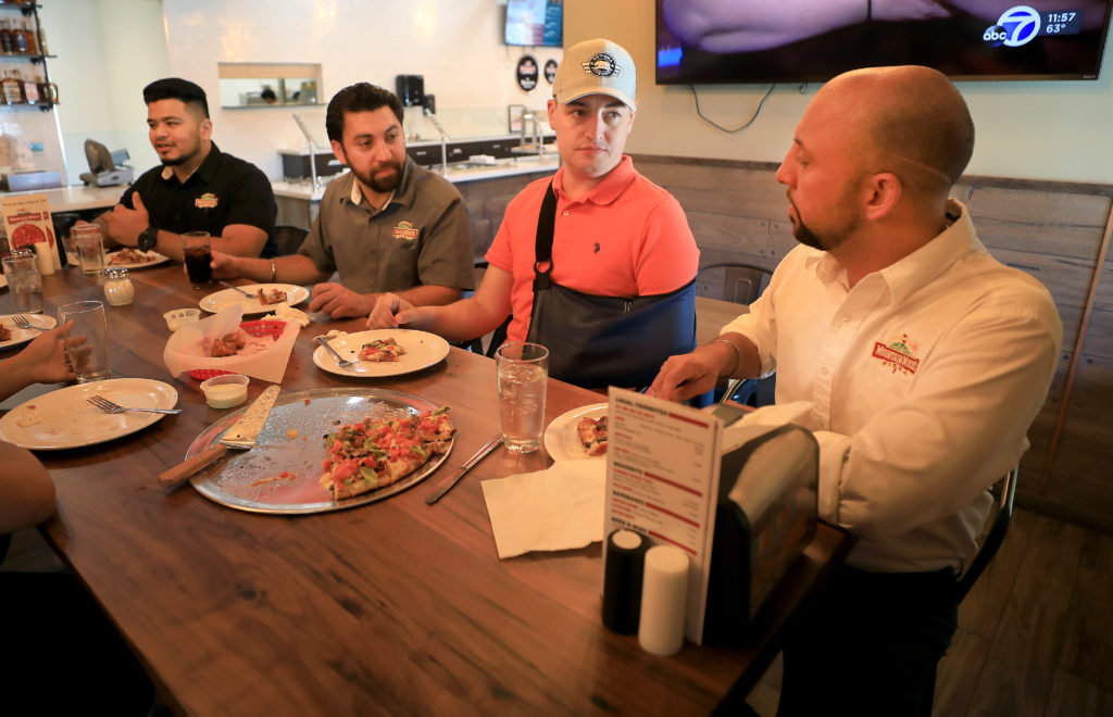 Jeff Okrepkie, middle, talks with Mountain Mike's Pizza co-owners Joti Chandi, left and Sonu Chandi during their reopening at a new location on Cleveland Ave. in Santa Rosa, Friday, July 5, 2019. Okrepkie lost his home in Coffey Park to the Tubbs fire in 2017. (Kent Porter / The Press Democrat)