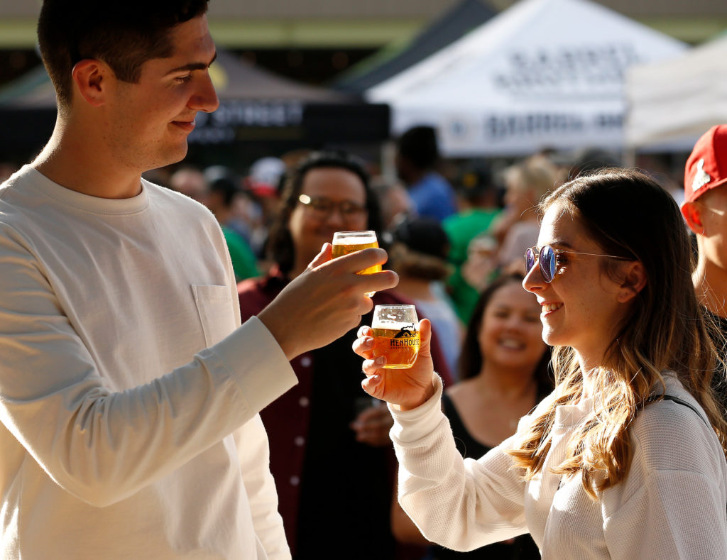 Jake Nichols, left, and Cassidy Barber, both of Rohnert Park, toast each other with some brews during HenHouse Brewing Company's Freshtival beer festival at SOMO Village Event Center in Rohnert Park, California, on Saturday, October 12, 2019. (Alvin Jornada / The Press Democrat)