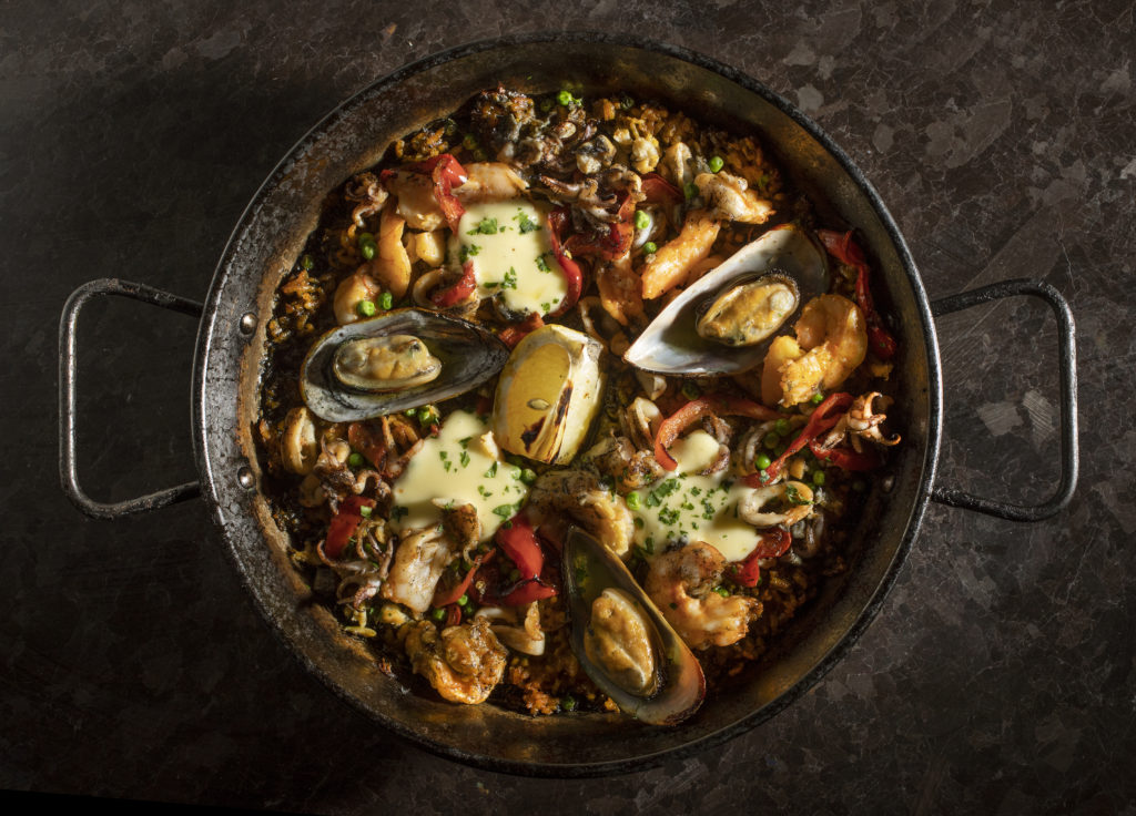 El Pescador Paella with sea clams, mussels, prawns, squid, sweet peas, arroz negro, peppers and aioli from Gerard's Paella. (John Burgess/The Press Democrat)
