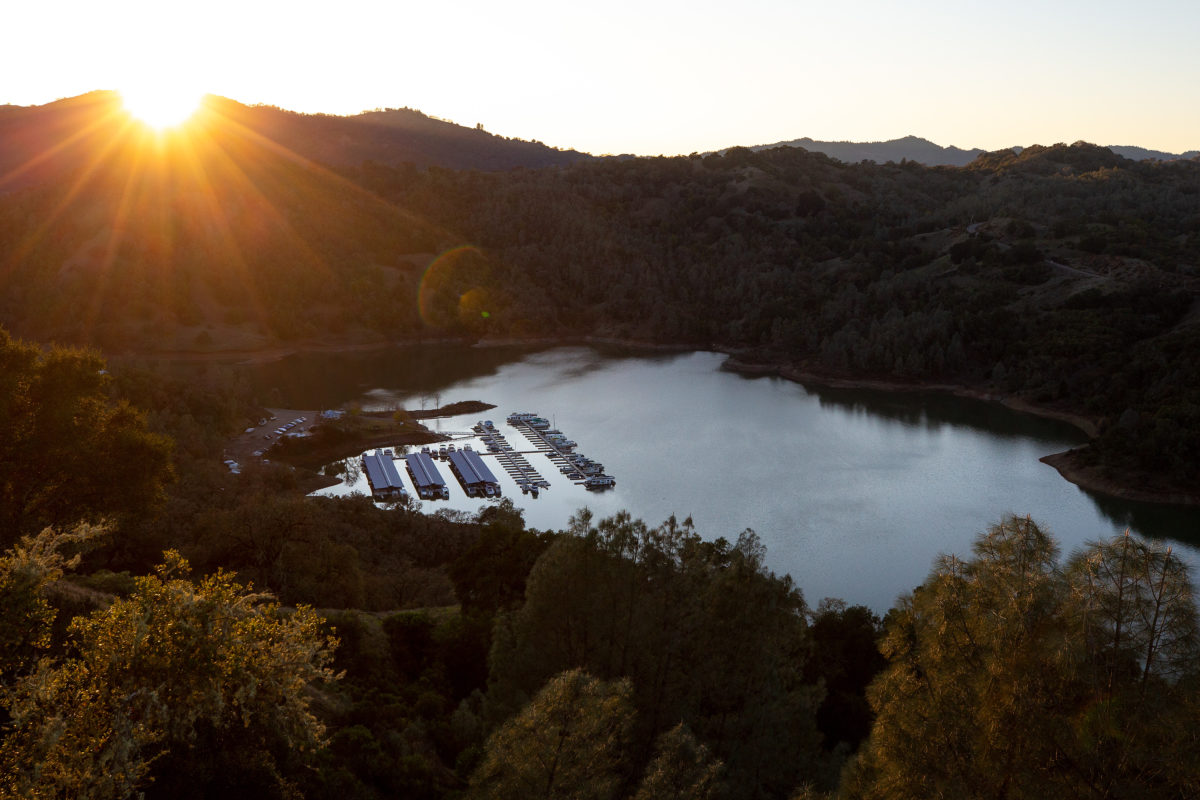 The sun sets behind the hills overlooking the Lake Sonoma Resort Area and marina, at Lake Sonoma in Geyserville, on Thursday, December 26, 2019. (Alvin Jornada / The Press Democrat)