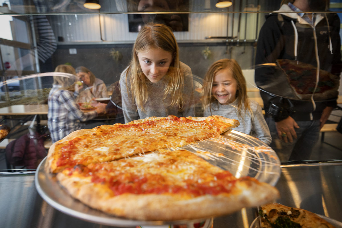 Sailor, left, and Lila Burt of Sebastopol check out the pizza varieties while their parent order at Acre Pizza in Sebastopol's Barlow district. (John Burgess/The Press Democrat)