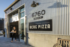 Wila Imhoff heads across the street to Crooked Goat Brewing with a to go Acre Pizza in Sebastopol's Barlow district. (John Burgess/The Press Democrat)