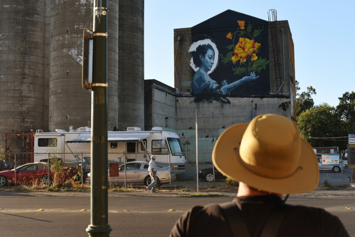 John Wentz at the end of a long work day examines his mural from across the street on Sebastopol Road during The Mural Festival in Roseland neighborhood of Santa Rosa on Monday, June 27, 2022. (Erik Castro / For The Press Democrat)