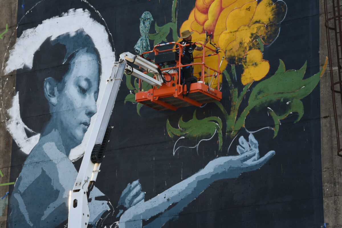 John Wentz, an Oakland based artist, working on his mural on the upper portion of building not in use on Sebastopol Road during The Mural Festival in Roseland neighborhood of Santa Rosa on Monday, June 27, 2022. (Erik Castro / For The Press Democrat)