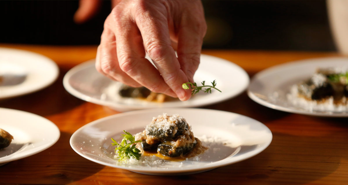 Chef Charlie Palmer finishes plates of Bucher pinot noir pork shoulder during Pigs and Pinot at Hotel Healdsburg, in Healdsburg, California, on Friday, March 16, 2018. (Alvin Jornada/The Press Democrat)