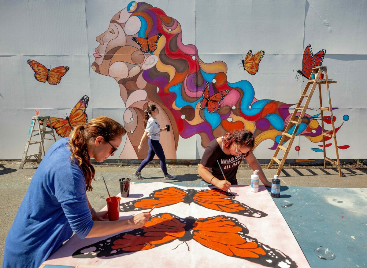 Emily Hostutler, left, an instructor from Sonoma State University and one of her students Paola Islas, right, who is also a DACA recipient, volunteer their time assisting Rima Makaryan, center, with painting butterflies for Makaryan's Dreamer Mural at Montgomery High School in Santa Rosa, California, on Saturday, March 30, 2019. (Alvin Jornada / The Press Democrat)