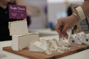 A festival attendee dipping into Truffle Tremor, a soft-ripen goat milk cheese during the 11th annual California Artisan Cheese Festival held at the Sheraton Sonoma County in Petaluma Sunday. March 26, 2017. (Erik Castro/for The Press Democrat)