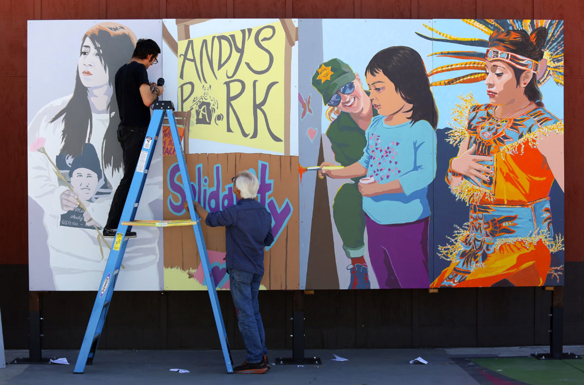 Artists Daniel Doughty and Mario Uribe hang the multi-panel "Healing Mural" they created honoring the memory of Andy Lopez at the Roseland Village Neighborhood Center. (John Burgess/The Press Democrat)