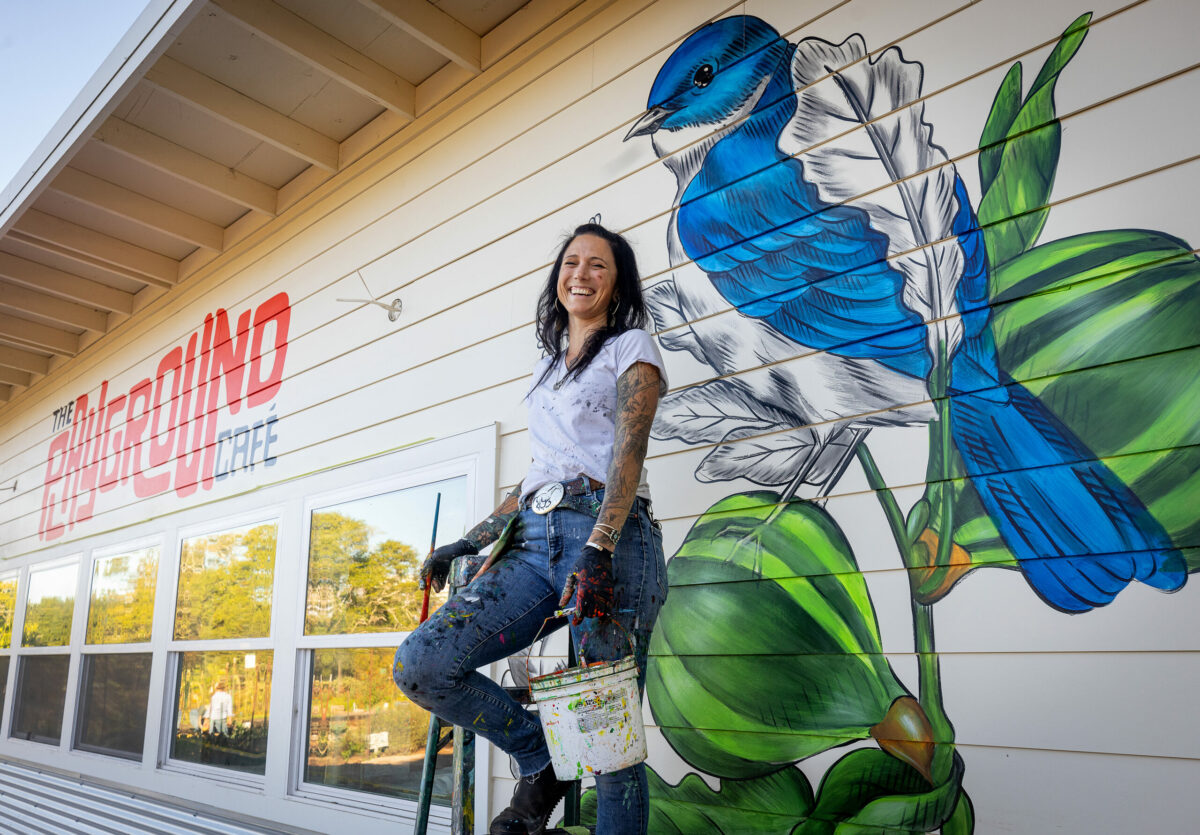 Muralist Amanda Lynn puts the final touches of color on a bluebird on a fig tree on the outer walls of The Playground Café at St. Stephen's Church Wednesday, Oct. 16, 2024, in Sebastopol. (John Burgess / The Press Democrat)