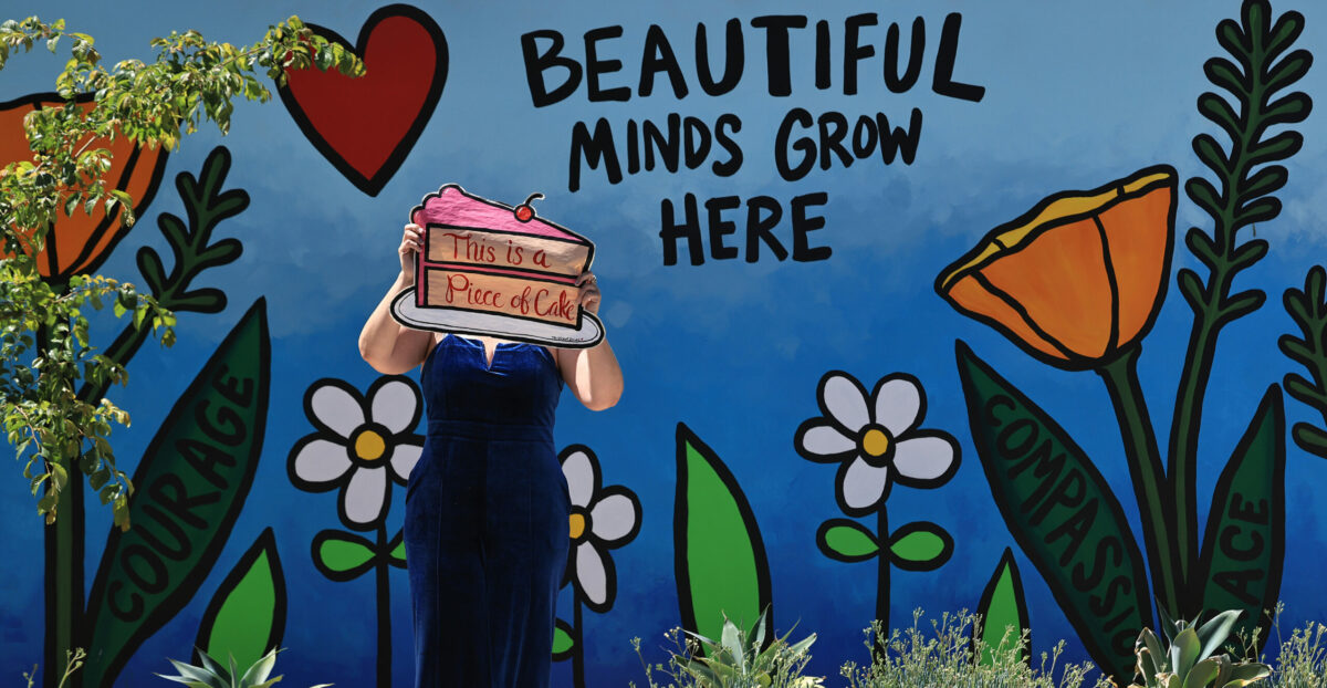 The Velvet Bandit with a mural she painted on the grounds of Anova Center for Education in Santa Rosa, Wednesday, July 2, 2025. (Kent Porter / The Press Democrat)