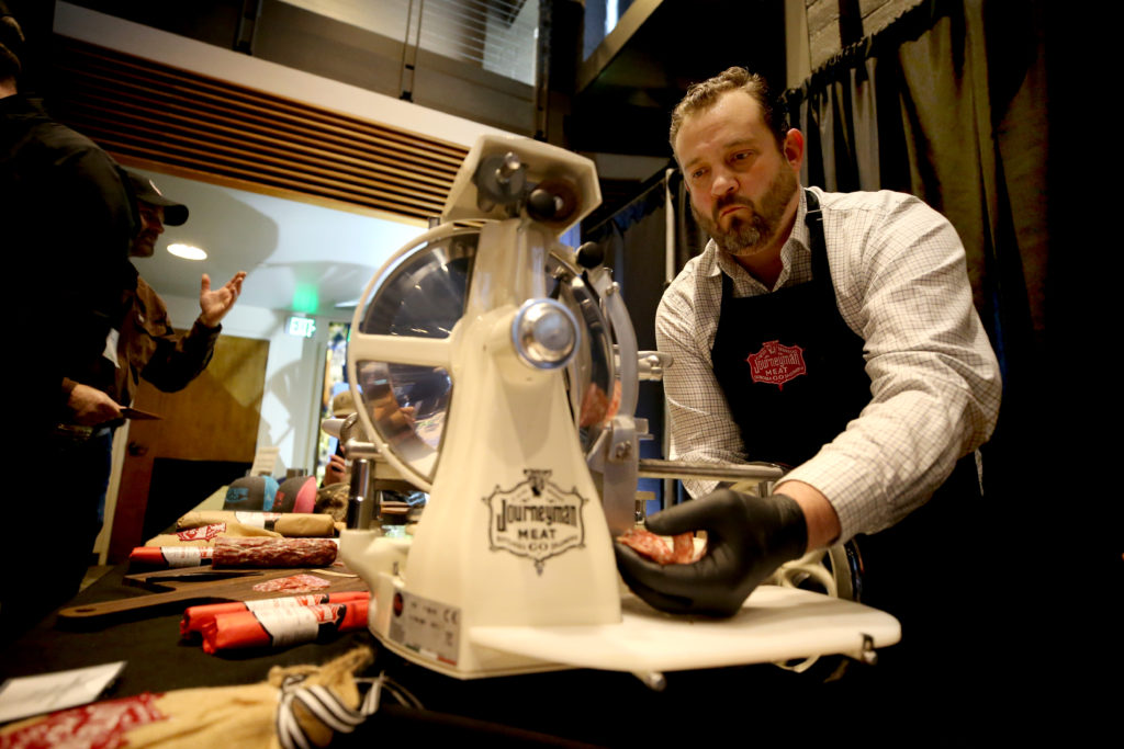Brian Moore slices artisan salame made by Journeyman Meat Co. during the 20th annual Sonoma County WinegrowersÕ Dollars & Sense trade show at the Luther Burbank Center for the Arts in Santa Rosa on Thursday, January 16, 2020. (BETH SCHLANKER/ The Press Democrat)