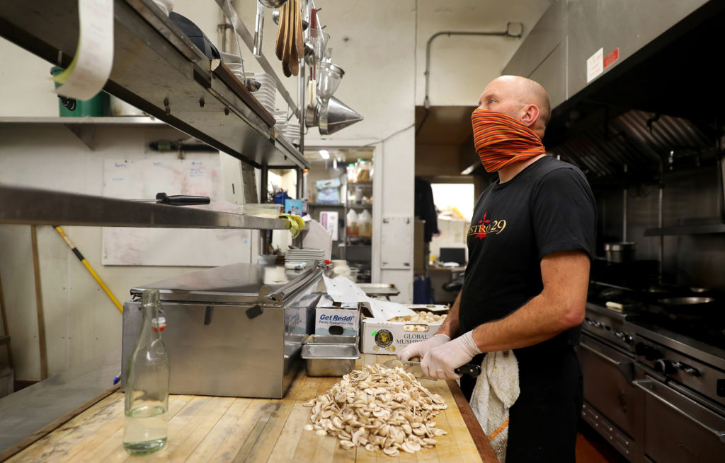 Brian Anderson watches a takeout order print out as he preps mushrooms at his Bistro 29 restaurant in Santa Rosa on Thursday, April 16, 2020. Anderson has announced that he will be closing the downtown on April 25. (Christopher Chung/ The Press Democrat)