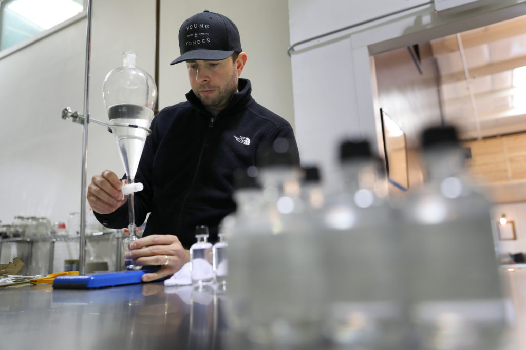 Josh Opatz, co-founder of Young & Yonder Spirits, bottles hand sanitizer created with alcohol from his Healdsburg distillery, on Tuesday, March 24, 2020. Opatz is giving the hand sanitizer away for free to the local community. (Christopher Chung/ The Press Democrat)