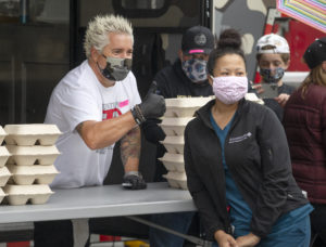 A hospital worker poses for a quick picture with celebrity chef Guy Fieri at Memorial Hospital on Wednesday. Fieri brought family, friends and his 48-foot Guy’s Smokehouse Stagecoach mobile kitchen to feed first responders and hospital workers lunch. (photo by John Burgess/The Press Democrat).