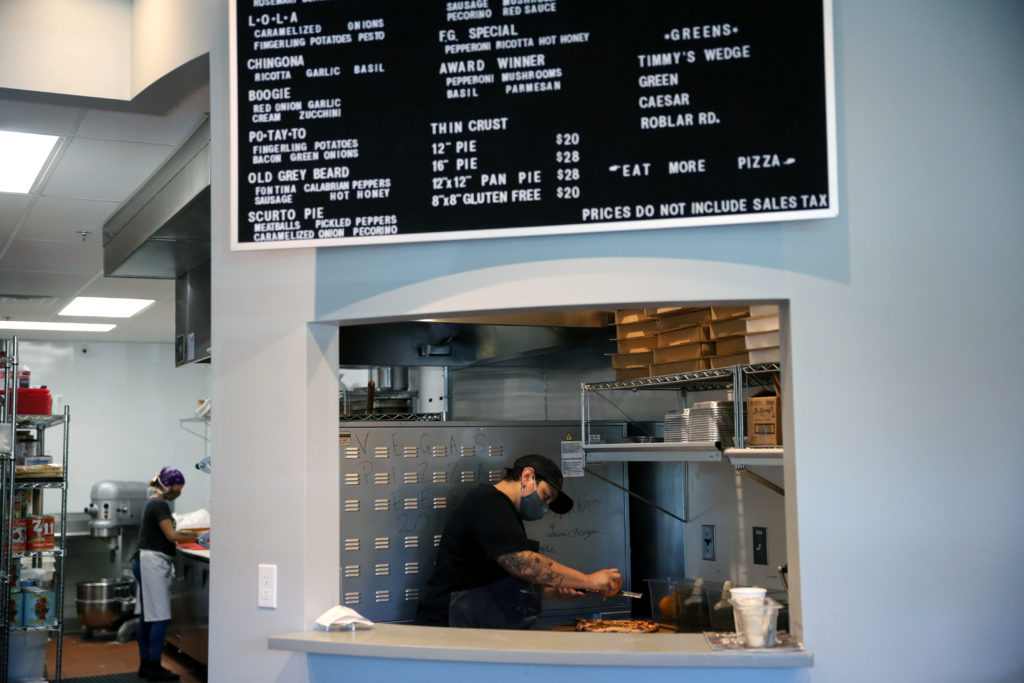 Leah Scurto, co-owner and executive pizza maker, zests an orange on top of the Old Grey Beard pizza after it came out of the oven at Pizza Leah in Windsor. (Beth Schlanker/The Press Democrat)