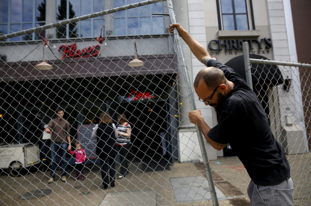 Rob Brock of Tri-City Fence Company assembled a chain link fence along the sidewalk in front of Flavor Bistro as work got underway on the reunification project of Old Courthouse Square in Santa Rosa, on Monday, May 23, 2016. (Beth Schlanker)