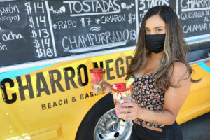 Laura Mederos, with the Charro Negro food truck, holds up their Aguachile de Camarón, left, and Ceviche de Camarón in the Roseland area of Santa Rosa. (Christopher Chung/The Press Democrat)