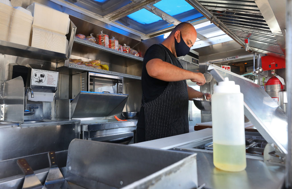 Charro Negro food truck owner Rodrigo Mendoza prepares an order for customers in the Roseland area of Santa Rosa on Wednesday, July 15, 2020. (Christopher Chung/ The Press Democrat)