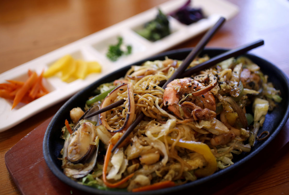 Yakisoba, a dish of seafood, wheat noodles, sauteed bell peppers and onion and Tsukemono, a platter of four pickled vegetables including turnips, carrots, eggplant and cucumber at Haku Sushi in Santa Rosa. (Beth Schlanker / The Press Democrat)