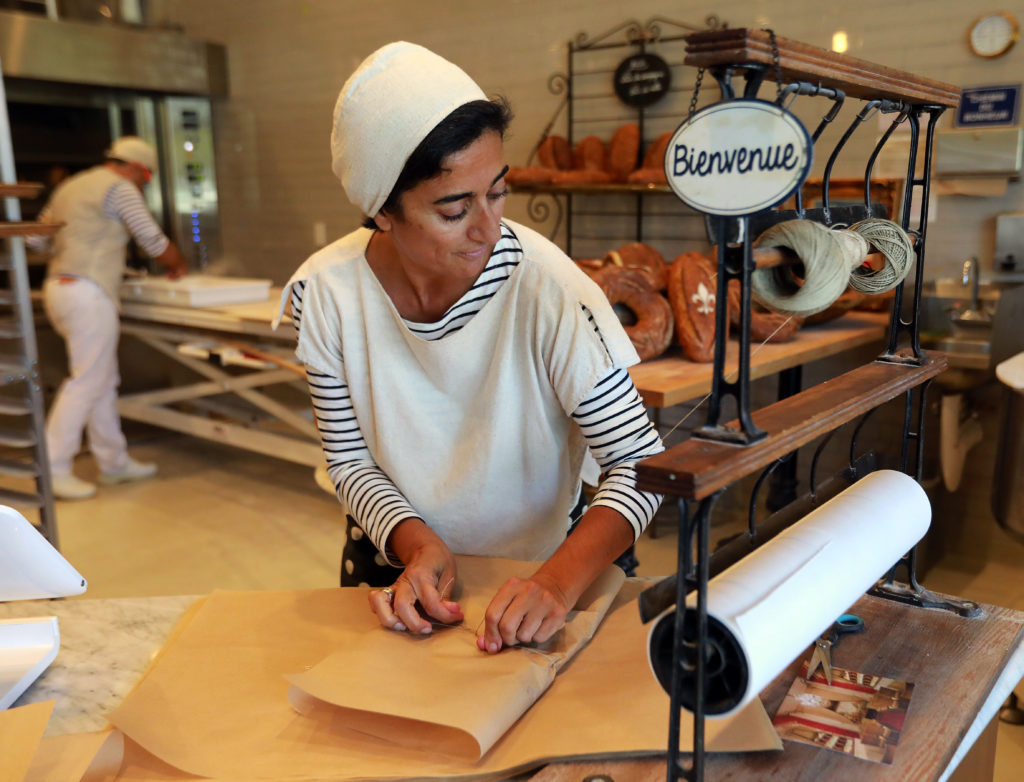 Najine Shariat wraps loaves of bread in paper and twine at Goguette Bread in Santa Rosa. (John Burgess/The Press Democrat)