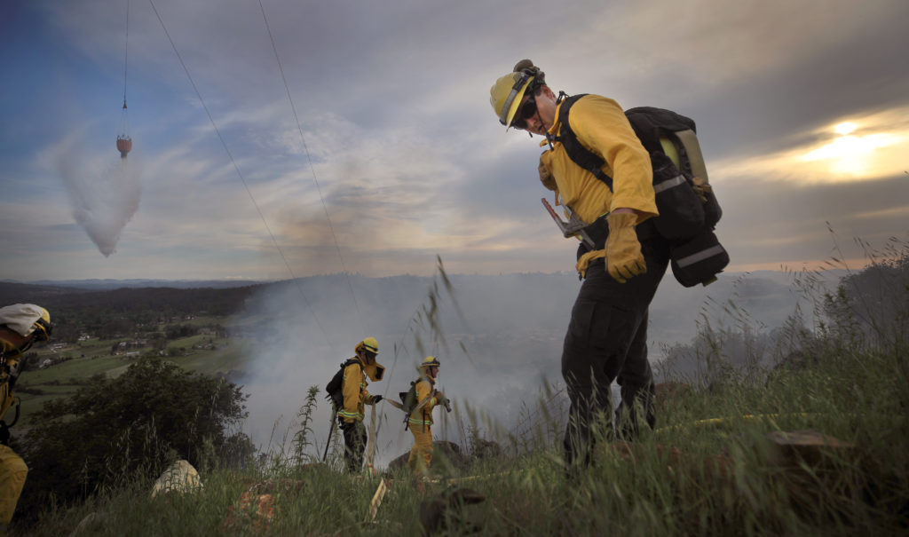 Firefighters with the Sonoma County Fire District prepare to extinguish a flames on a brush fire in Rincon Valley on Rolling Oaks Road, Thursday, April 30, 2020. (Kent Porter / The Press Democrat) 