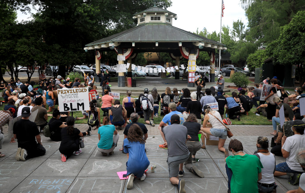 Protesters kneel in memory of George Floyd at the Healdsburg Plaza, during a protest of racial inequality and police mistreatment, Thursday, June 11, 2020 in Healdsburg. (Kent Porter / The Press Democrat) 2020