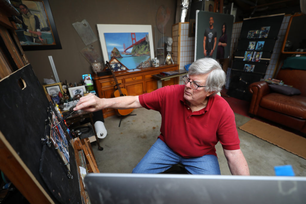 Artist John Deckert works on a painting of a pair of firefighters, at his home in Santa Rosa on Thursday, April 23, 2020. Deckert is making small paintings of essential workers, performing their duties during the shelter in place. (Christopher Chung / The Press Democrat)