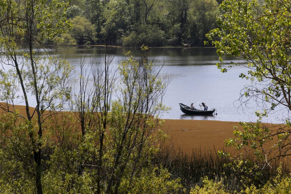 A pair of fisherman float near a large bloom of azolla, a type of aquatic fern, at Spring Lake Regional Park on Tuesday, April 24, 2018 in Santa Rosa, California . (BETH SCHLANKER/The Press Democrat)
