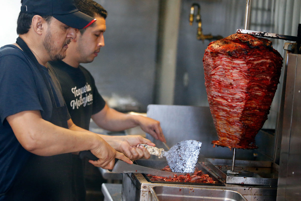 Ramiro Morales prepares tacos al pastor that was cooked the traditional way on a trompo, right, at Taqueria Molcajetes, in Santa Rosa, on Wednesday, April 25, 2018. (Alvin Jornada / The Press Democrat)