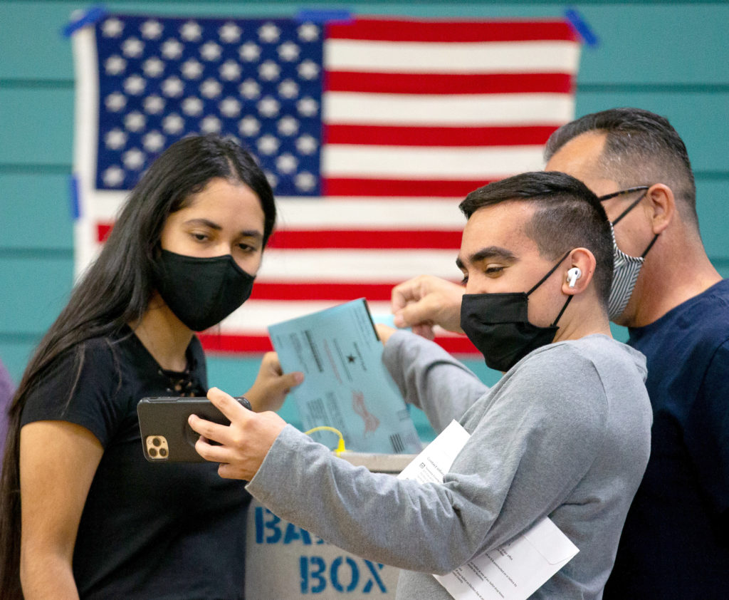 First-time voters James Brady and his sister Micaela snap a selfie with their father James as they place their ballots into a ballot box on Election Day at the Sonoma County Fairgrounds, in Santa Rosa, California, on Tuesday, November 3, 2020. (Alvin A.H. Jornada / The Press Democrat)