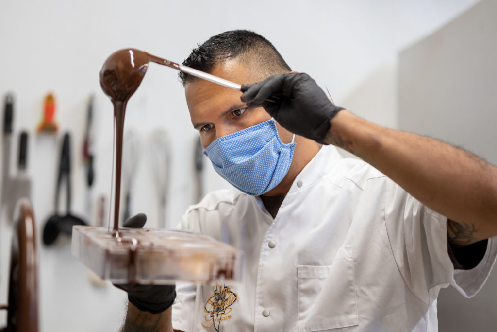 Robert pours tempered chocolate into a mold. (Chris Hardy / Sonoma Magazine)