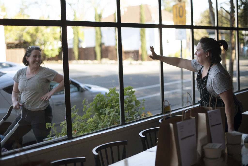 ÒI catered her wedding,Ó said Chef and owner Liza Hinman, right, as she waved to Ria DÕAversa who came to pickup her curbside delivered dinner at The Spinster Sisters restaurant in Santa Rosa, California on April 2, 2020. (Photo: Erik Castro/for Sonoma Magazine)