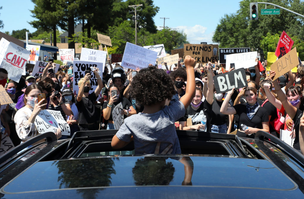 Five-year-old Cairo Diaz holds his fist in the air as protestors block the intersection of Mendocino Avenue and College Avenue, in Santa Rosa on Monday, June 1, 2020. (Christopher Chung/ The Press Democrat)