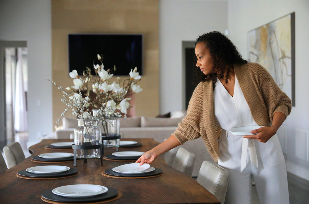 Interior designer Stephanie Meyer arranges a table setting at a client's home in Santa Rosa on Friday, November 13, 2020. (Christopher Chung/ The Press Democrat)