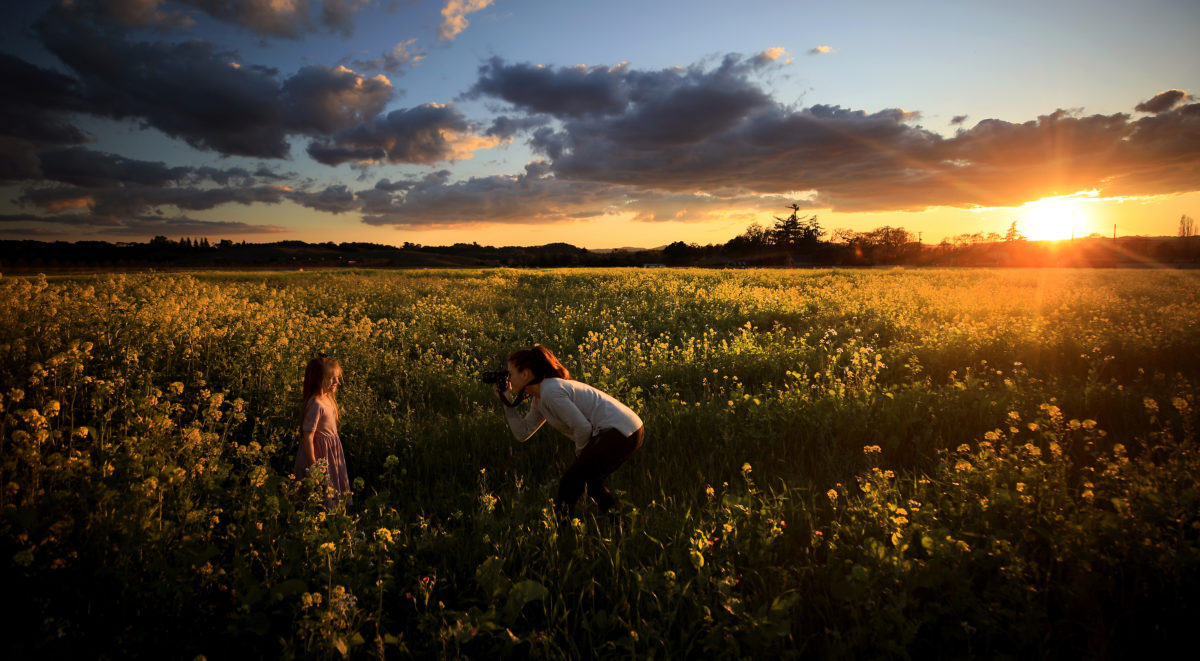 Alyssa Groff photographs Evalette, one of her three daughters, in a mustard field at sunset in the Alexander Valley, March 20, 2020. (Kent Porter / The Press Democrat)