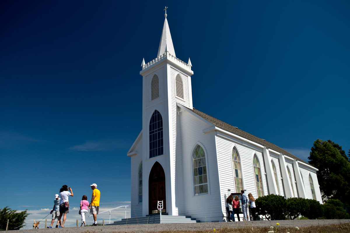 Visitors walk around the Saint Teresa de Avila Church, during the B50 Festival, celebrating the 50th anniversary of Alfred Hitchcock's film The Birds, in Bodega, Calif., on September 1, 2013. (Alvin Jornada / For The Press Democrat)